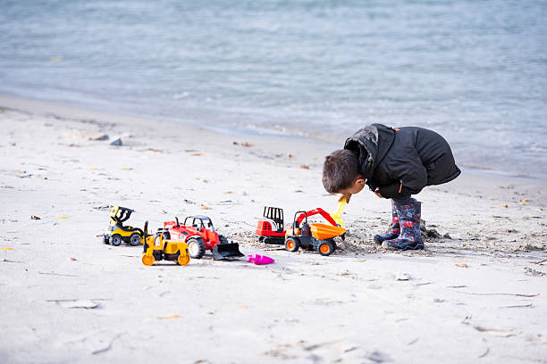 Little boy playing in the sand on the beach.