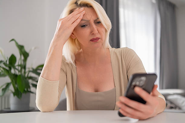 istock Anxious woman staring at smartphone with troubled face 2231417822