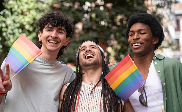 istock Happy multi-ethnic friends celebrating gay pride holding rainbow flags 2231419010