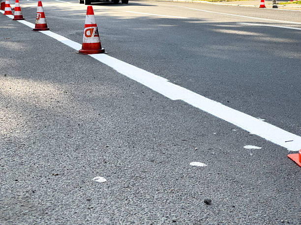istock Traffic cones outline a freshly painted white line on the road during a construction project, ensuring safety for passing vehicles 2231422760