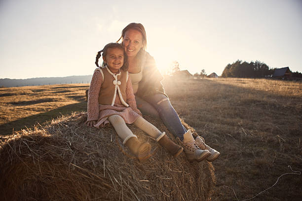 Happy girl in nature with mother. It’s beautiful autumn day. Sunset vibes.