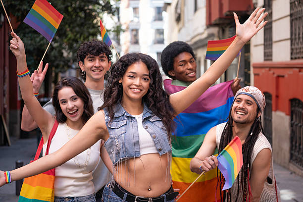 istock Young activists celebrating with rainbow flags at pride parade 2231426069