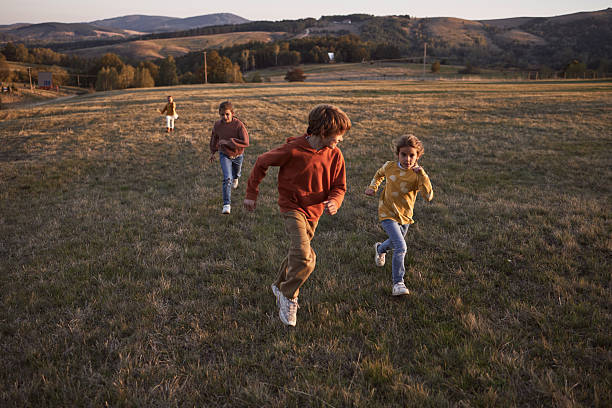 Happy kids running in nature on sunset. It’s beautiful autumn day.