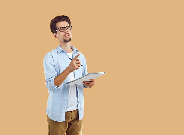 istock inspired man holding notebook pointing index finger up having new idea 2231426589