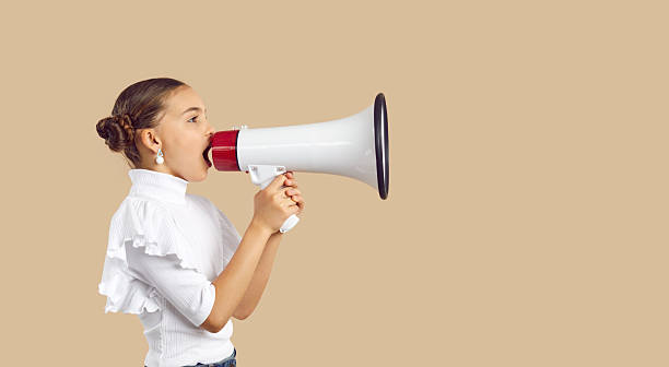 istock Little child with megaphone making announcement, sharing message or promoting event 2231426696