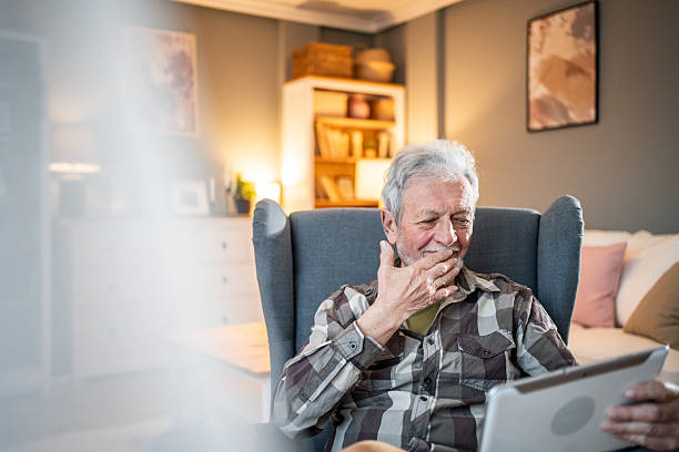 istock Senior man using digital tablet at home, enjoying video call 2231429513