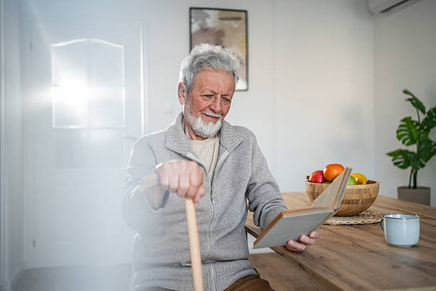 istock Senior man reading a book and relaxing at home 2231430968