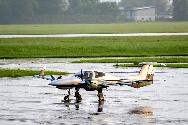 istock A small twin-engine aircraft is parked on a wet runway after rainfall 2231431075