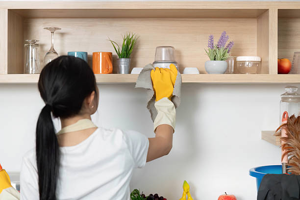 istock Shelf Cleaning. Woman dusting shelves in a tidy kitchen environment. 2231432011