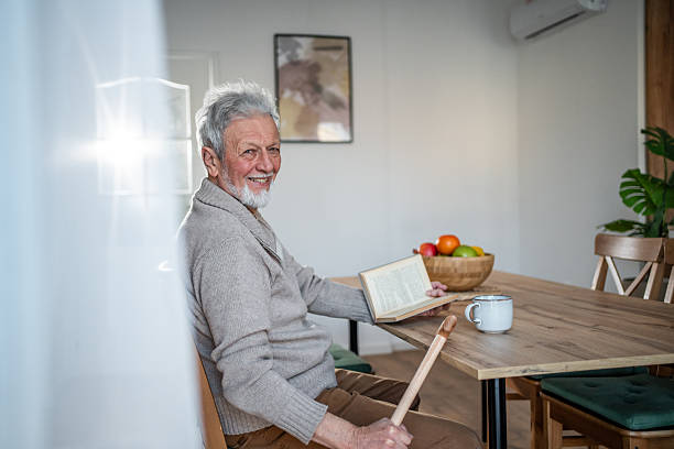 istock Senior man enjoying reading a book at home 2231433586