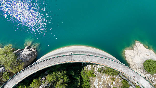 istock Curved bridge spanning tranquil waters under a bright sun in a picturesque natural setting 2231435645