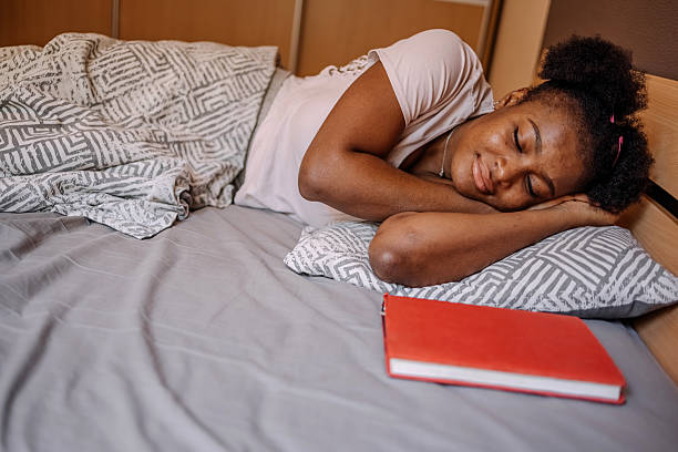 istock Young female sleeping at home in her bedroom 2231436573