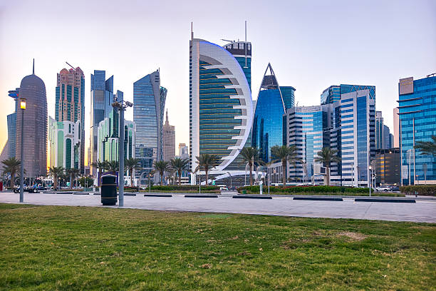 istock Beautiful panoramic view of Doha skyline at sunset. Skyscrapers glow in warm evening light, reflecting in calm waters of the bay. Modern architecture in Qatar's capital city. 2231438362