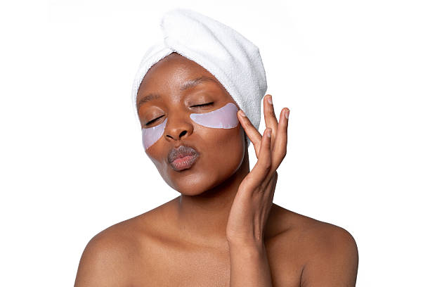 istock Woman applying under-eye patches while enjoying a skincare routine, relaxing at home during daytime with a towel on her head 2231440836