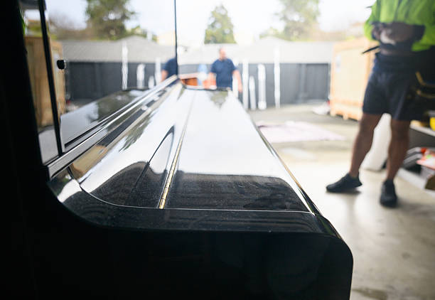 Unrecognizable workers preparing to move a piano. Concept of home moving and delivery.
