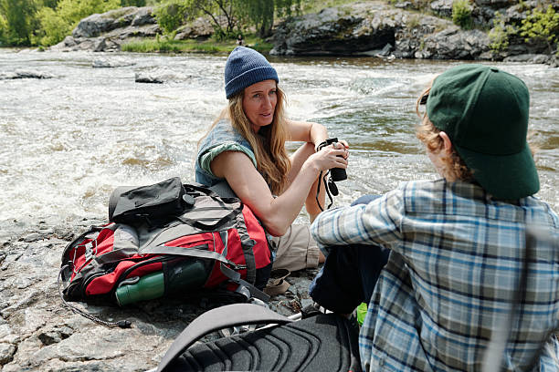 istock Woman and Man Resting by River during Hike 2231441463