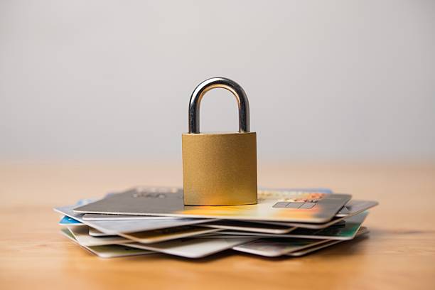 istock Padlock on stack credit cards on wooden table with white wall background. 2231442281