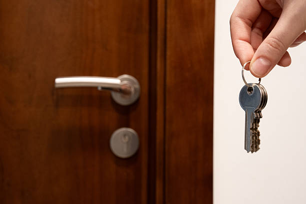 istock Hand with keys near brown door 2231443094