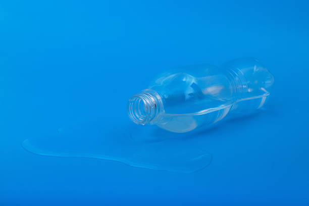 istock Spilled water from plastic bottle on blue background 2231444852