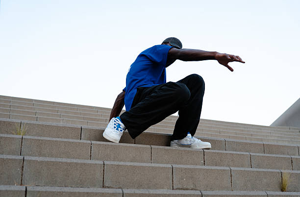 istock Young man breakdancing on urban concrete stairs, showcasing impressive moves and dynamic energy in a vibrant city setting 2231446573