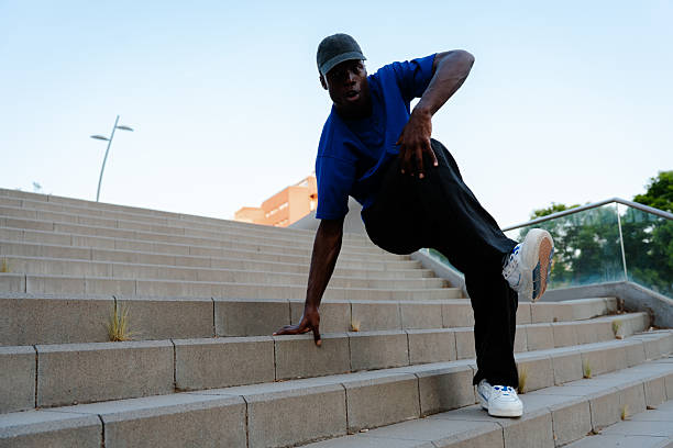 istock Young man breakdancing on concrete steps, showcasing skill and energy in an urban environment filled with vibrant city life 2231446583