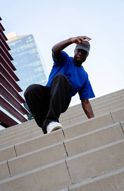 istock Young breakdancer executing dynamic move on urban steps, contemporary skyscrapers framing street performance 2231446637