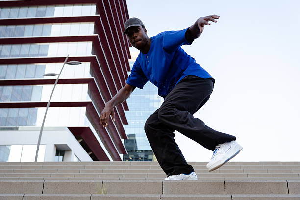istock Urban dancer performing dynamic street dance move on concrete stairs, expressing artistic motion against architectural background 2231446838