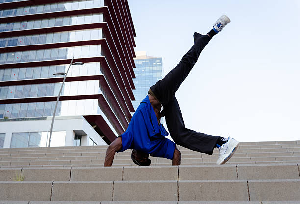 istock Breakdancer performing dynamic street moves, leaping across concrete steps with athletic precision and urban street style 2231447222