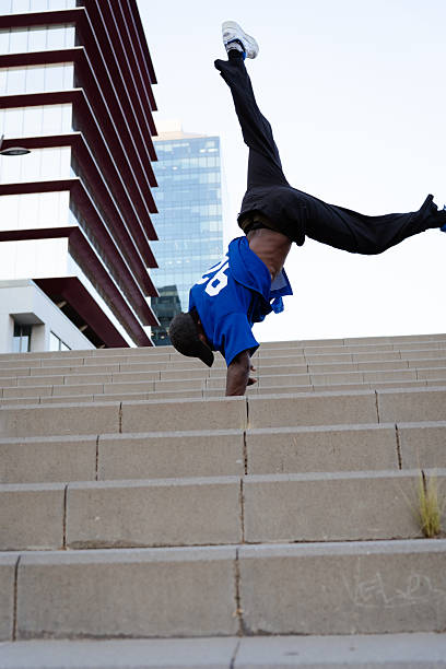istock Breakdancer executing handstand on concrete urban steps, displaying athletic prowess against metropolitan street background 2231447246