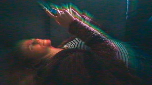 istock Woman Using Smartphone with Rainbow Light Trails Emanating from Screen 2231447898