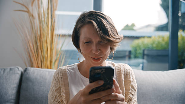 istock Woman Using Smartphone and Relaxing on Sofa at Home 2231448998