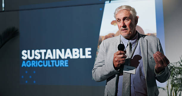 istock Microphone, presentation and seminar with business man in auditorium for sustainable agriculture. Development, speech and symposium with mature speaker on podium or stage for farming conference 2231457706