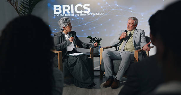 istock Interview, presentation or speech with business people on stage for BRICS conference or discussion. Development, microphone and question with mature speakers in auditorium for international trade 2231457744