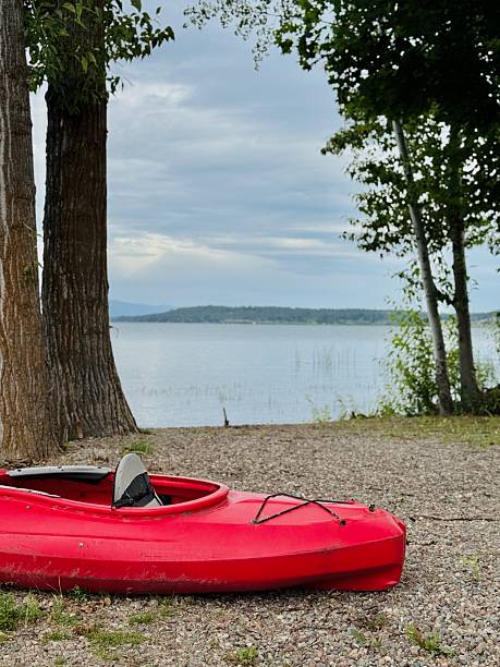 istock Red kayak beached on a lake shore 2231461564
