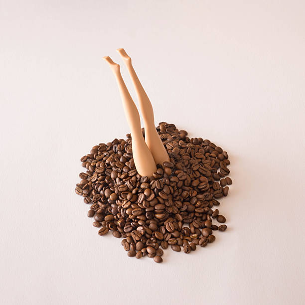 istock Doll legs emerging from a pile od coffee beans.Creative coffee drink concept.Unique flat lay 2231464166