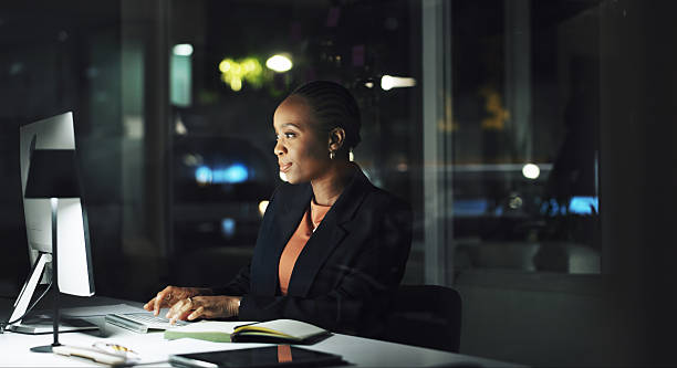 istock Black woman, typing and computer in office at night for research, editing article and feedback. Journalist, pc and report with story update, review newsletter and information on publication deadline 2231465641