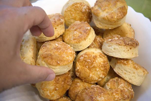 Freshly baked Hungarian cheese scones in hand, traditional homemade pastry close-up.