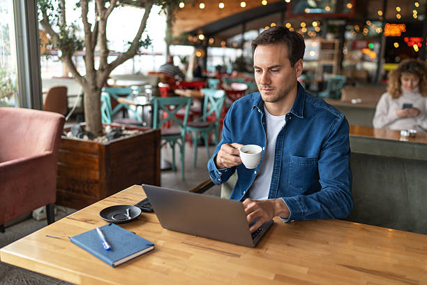 istock Freelancer working on laptop and drinking coffee in cafe 2231470087