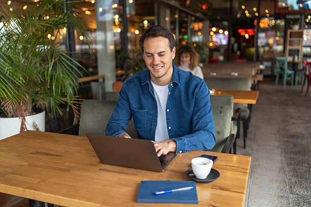 istock Young freelancer working on laptop in cozy cafe 2231470143
