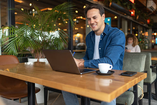 istock Freelancer working on laptop in cafe, enjoying a cup of coffee 2231470268