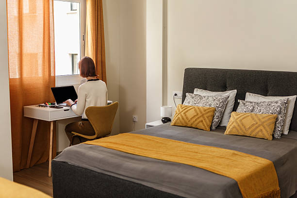 istock Cozy modern bedroom with workspace, warm colors, and natural light 2231471164