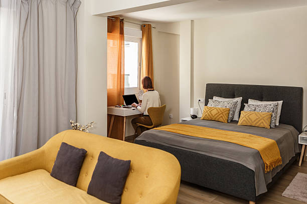 Cozy modern bedroom with workspace, warm colors, and natural light