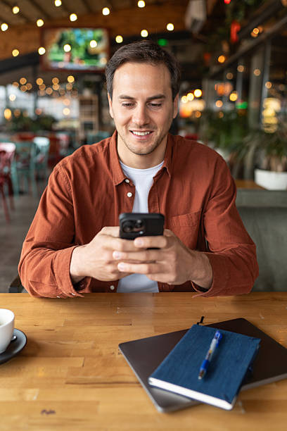 istock Young adult man using smartphone in a restaurant 2231472337