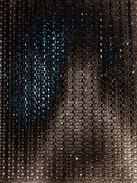 Abstract background featuring a metallic grid texture with dark tones and subtle lighting. Ideal for design, tech, and industrial themes.