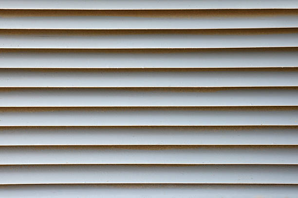 istock Ventilation grille with white metal slats horizontally covered with dust 2231477083