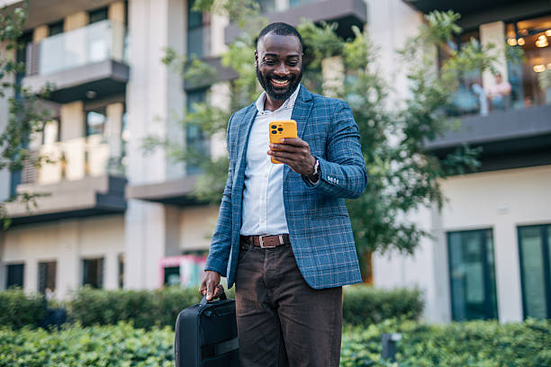 istock Smiling businessman using smartphone outdoors in urban setting 2231478369