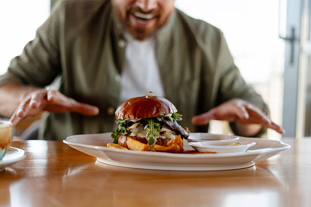 istock Hungry customer looking at delicious burger in restaurant 2231479709