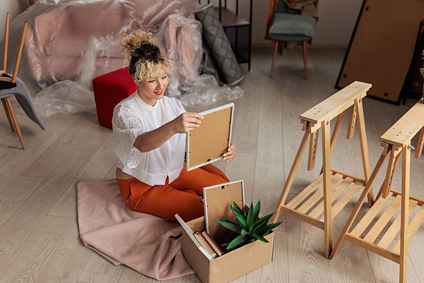 istock Smiling woman unpacking boxes in new home 2231480432