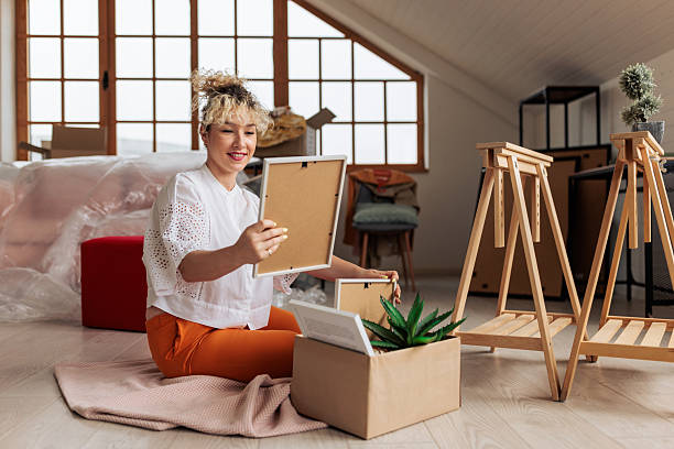 istock Smiling woman unpacking boxes in new home 2231480452