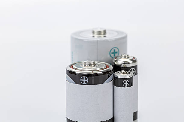 istock Various size batteries with metallic tops and white labels, arranged on white background, showing positive terminals and clean, minimal design 2231480563